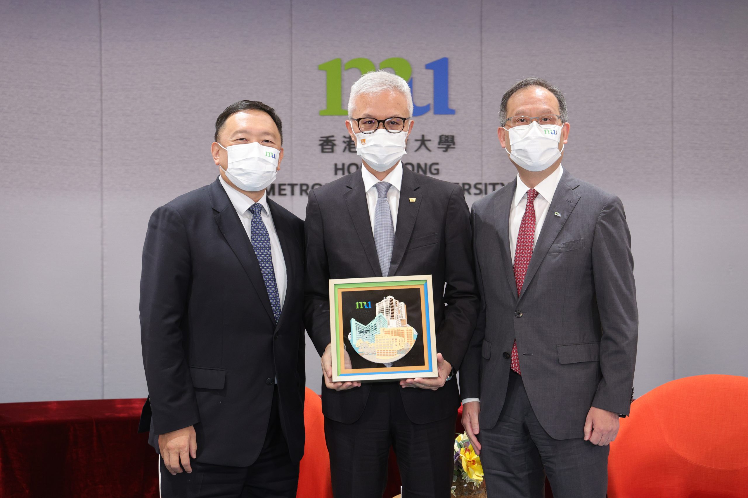 HKMU Council Chairman Ir Dr Conrad Wong Tin-cheung (left) and President Prof. Paul Lam Kwan-sing (right) present a souvenir to Director of the Hong Kong Palace Museum Dr Louis Ng Chi-wa (middle).