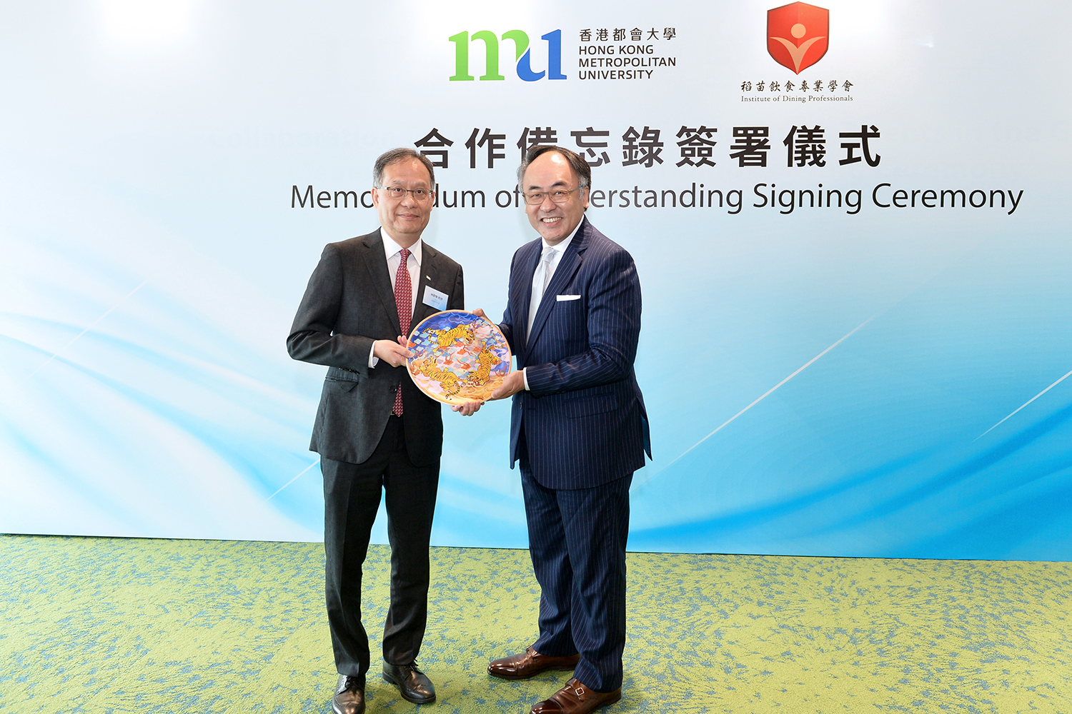 HKMU President Prof. Paul Lam Kwan-sing (left) exchanges souvenirs with IDP Chairman Maurice Kong Chi-hang.