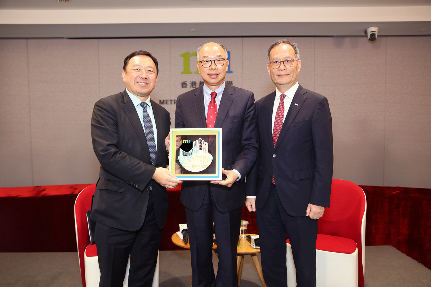 HKMU Council Chairman Ir Dr Conrad Wong Tin-cheung (left) and President Prof. Paul Lam Kwan-sing (right) present a souvenir to Ir Prof. Frank Chan Fan.