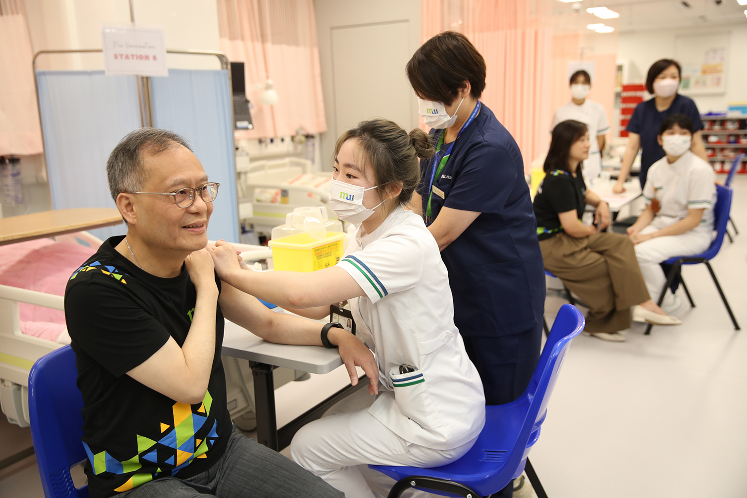 A professionally trained nursing student administers the vaccine to President Prof. Paul Lam Kwan-sing.